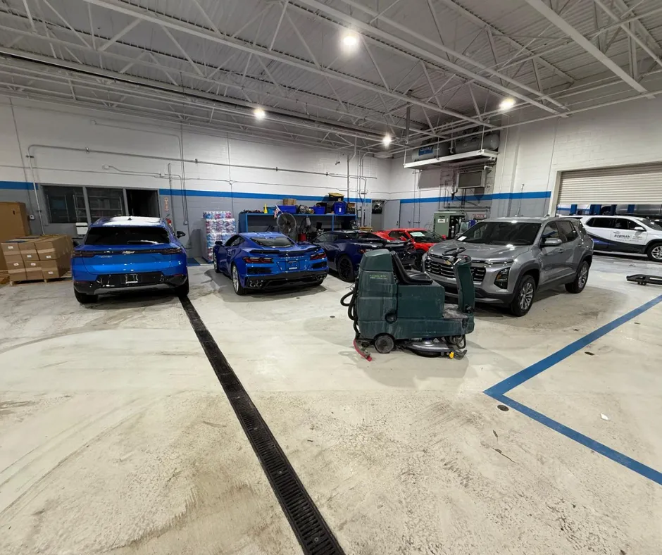 Nobles SS Rider floor scrubber parked inside a diesel repair shop surrounded by vehicles and service equipment, showcasing industrial floor cleaning capabilities for automotive and heavy-duty maintenance facilities.